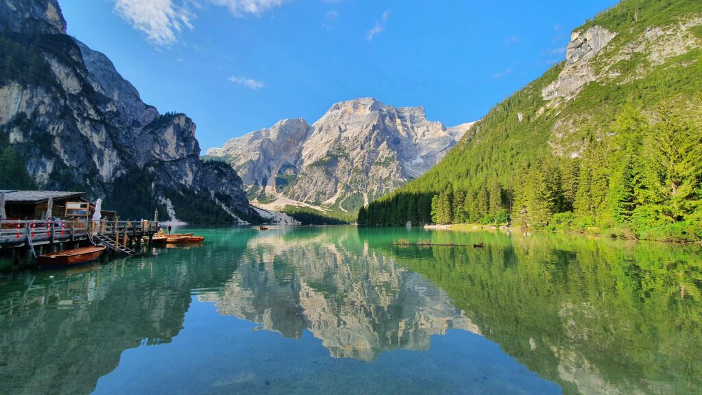 Beautiful reflection of the Dolomites in Lake Braies under a clear blue sky.